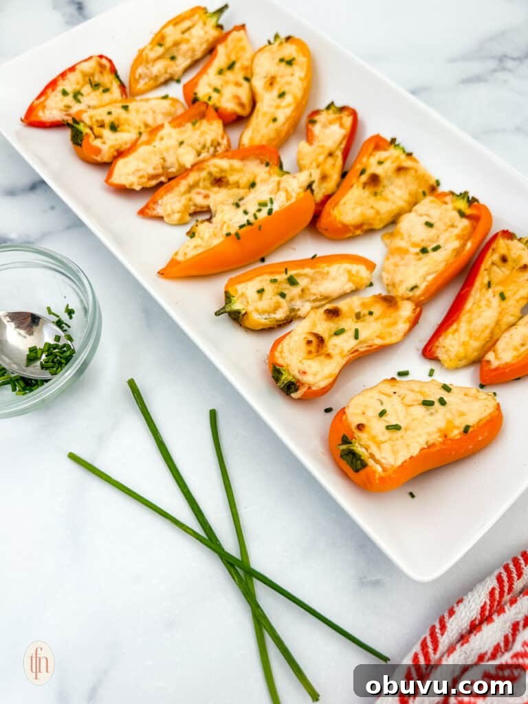 White plate topped with mini stuffed peppers on a white background.