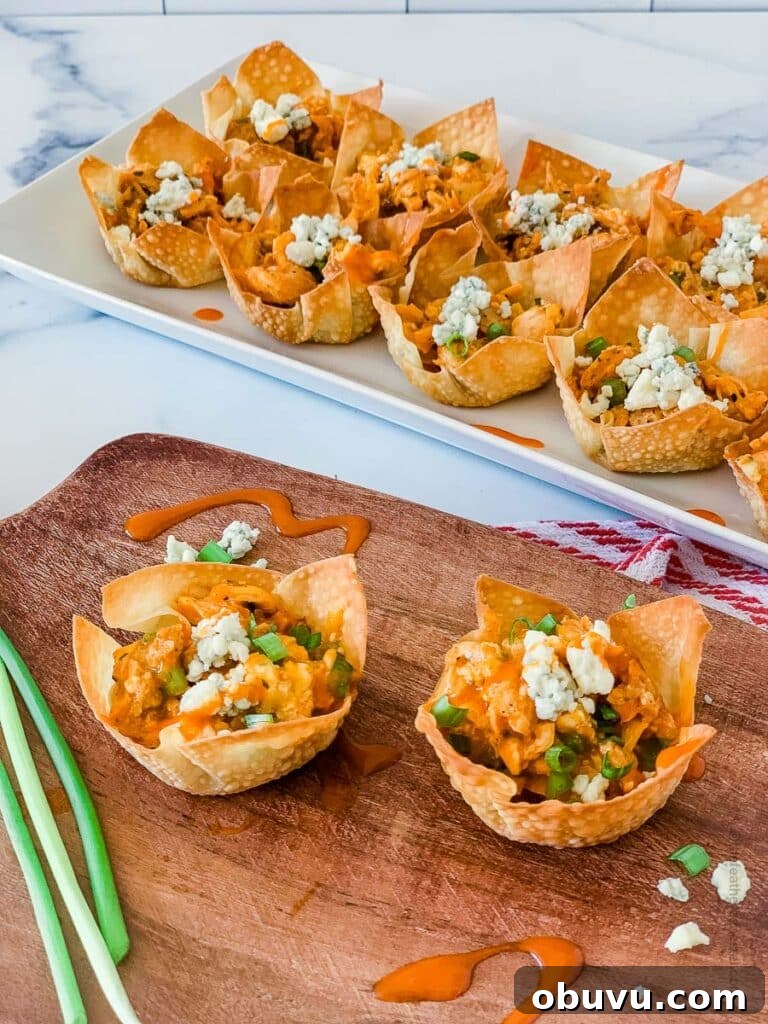 buffalo chicken wonton cups placed in a wooden serving tray and white serving plate.