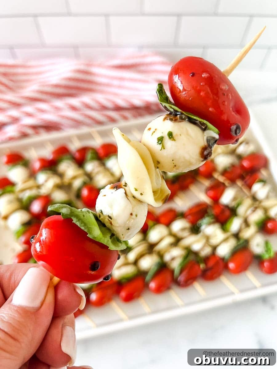 40+ Crowd-Pleasing Finger Food Ideas for Parties and Gatherings 43 a closeup of a caprese tortellini appetizer with a tray of caprese skewers with balsamic glaze
