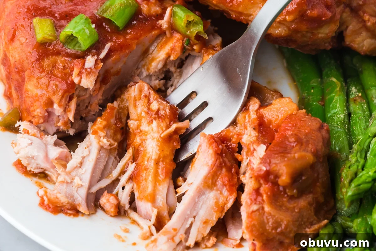 Tender Slow Cooker BBQ Pork Chops | Juicy, Hands-Off Recipe 6 fork cutting into serving of slow cooker bbq pork chops.
