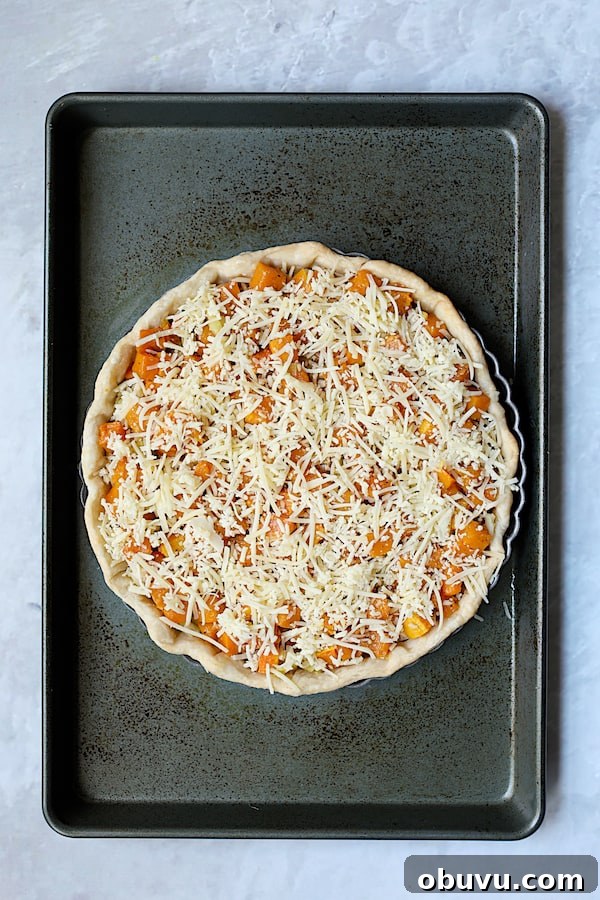 Photo of assembled Butternut Squash Leek and Gruyere Tart on baking sheet before custard is added.