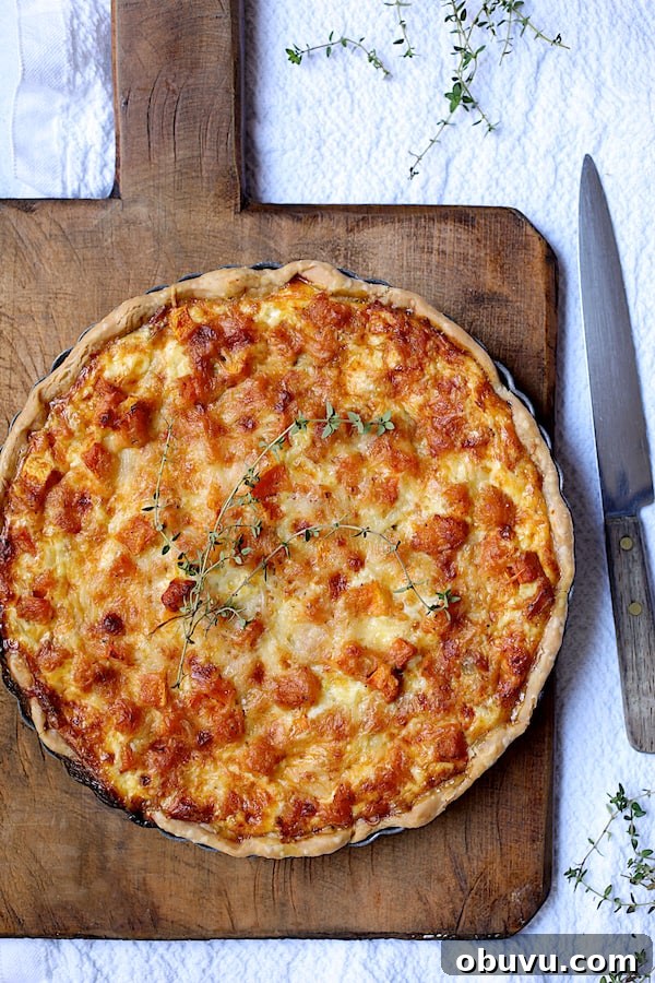 Photo of baked Butternut Squash Leek and Gruyere Tart on wood board.