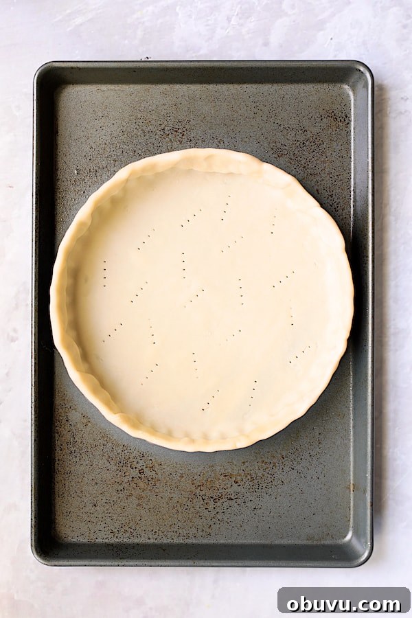 Photo of unbaked tart crust in tart pan on baking sheet.