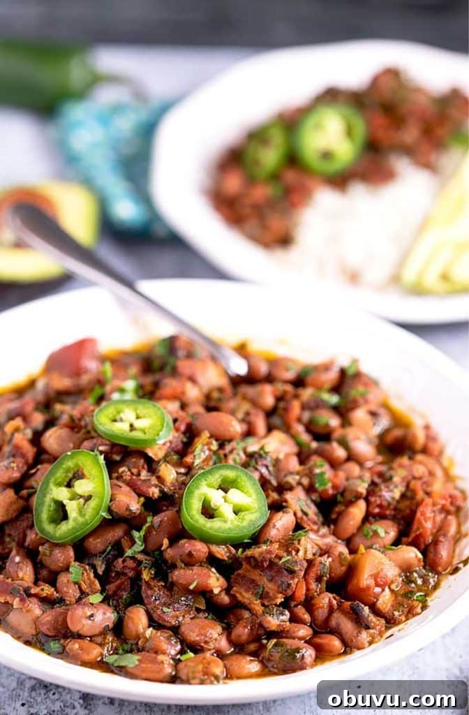 Authentic Charro Beans Recipe (Ranchero Beans) 12 Pinto beans Mexican style in a white bowl.