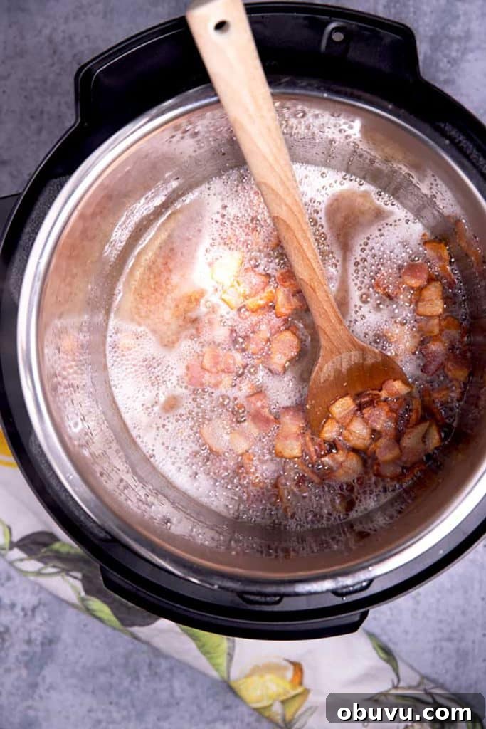 Authentic Charro Beans Recipe (Ranchero Beans) 6 removing the bacon from the bacon fat with a wooden spoon