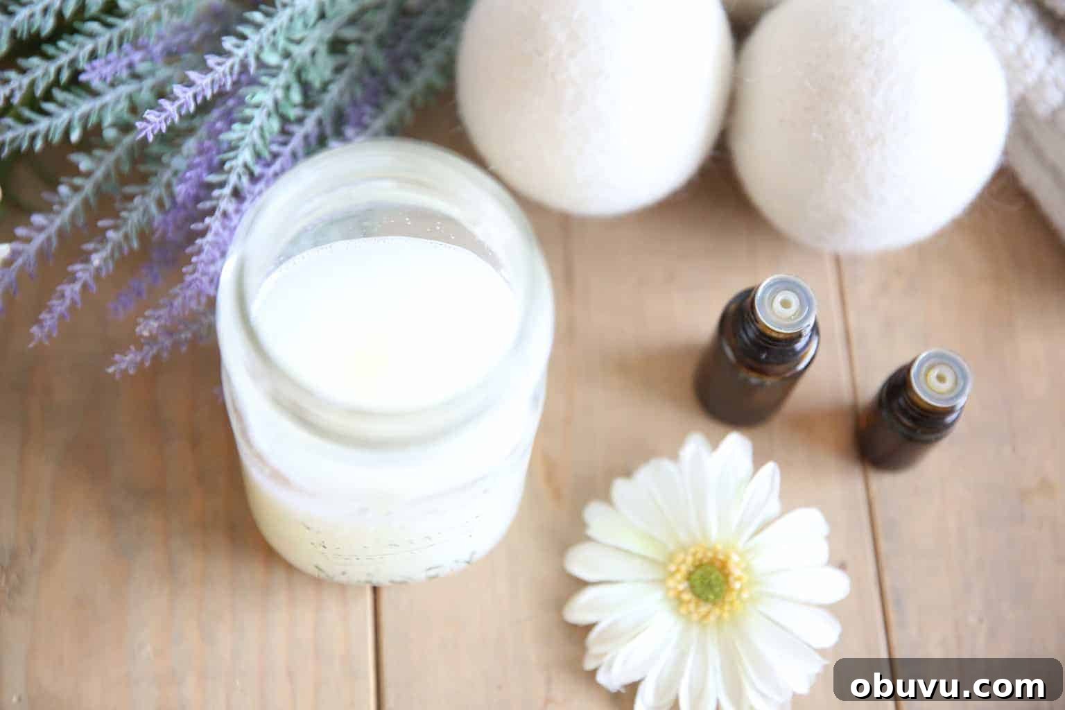 Make Your Own Laundry Soap: Simple DIY Recipe for Clean Clothes 2 Homemade laundry soap in mason jar with dryer balls on wooden table.