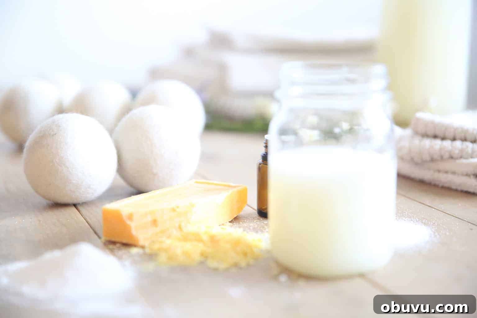 Make Your Own Laundry Soap: Simple DIY Recipe for Clean Clothes 12 Natural dryer balls with natural laundry detergent and a shredded soap bar on the tabletop.