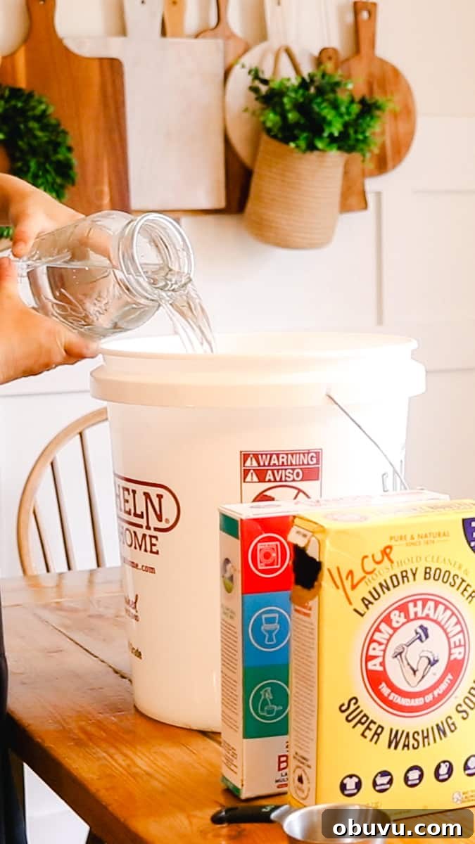 Make Your Own Laundry Soap: Simple DIY Recipe for Clean Clothes 5 Adding the first part of water to the container.