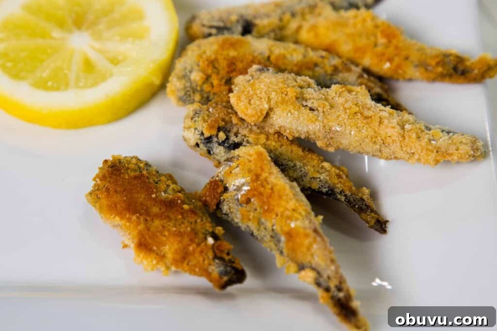 Crispy Keto Fried Sardines: Low-Carb Pan-Fried Recipe 2 Low carb Crispy Fried Sardines on a plate with lemon