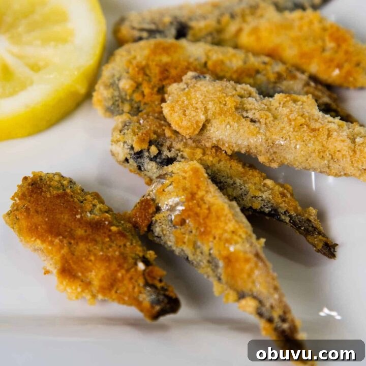 Low carb Crispy Fried Sardines on a plate with lemon