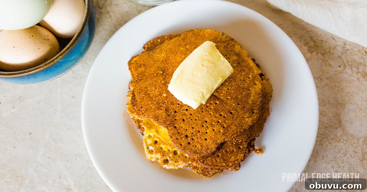 19 Cozy Low-Carb Breakfasts You’ll Crave Every Morning 9 A stack of cream cheese pancakes on white plate with butter.