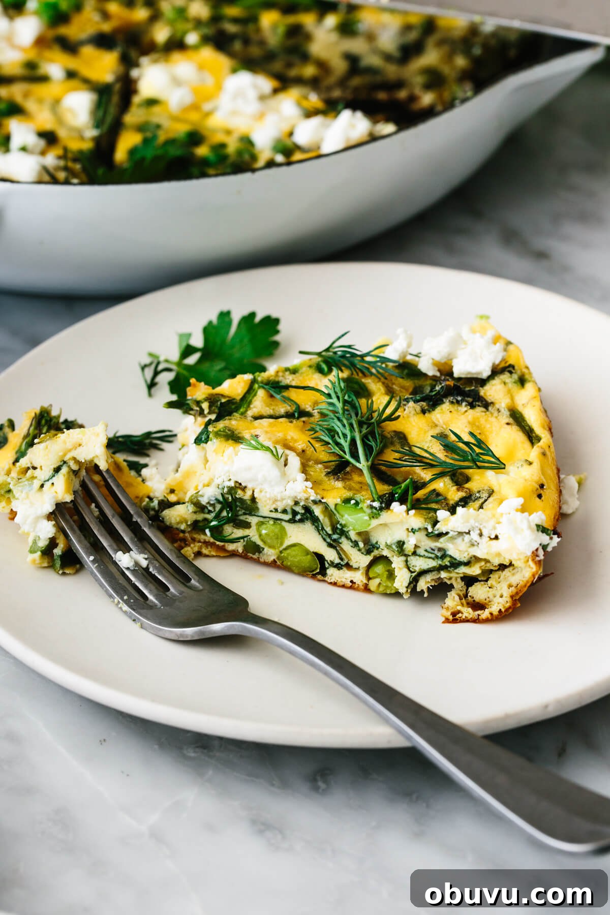 20 High-Protein Breakfast Recipes for Lasting Energy 14 A slice of spring vegetable frittata on a plate