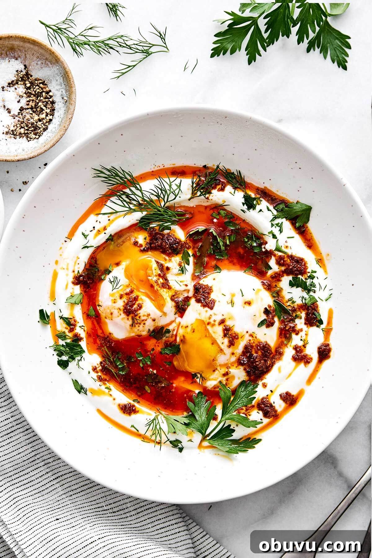 20 High-Protein Breakfast Recipes for Lasting Energy 4 A plate of Turkish eggs with herbs.