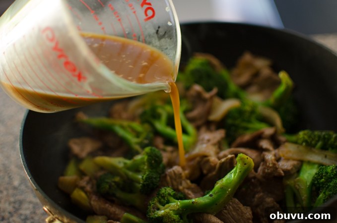 Chinese Beef and Broccoli Stir-Fry Recipe with Savory Sauce 10 Stir-fry sauce added to beef and broccoli in a wok.