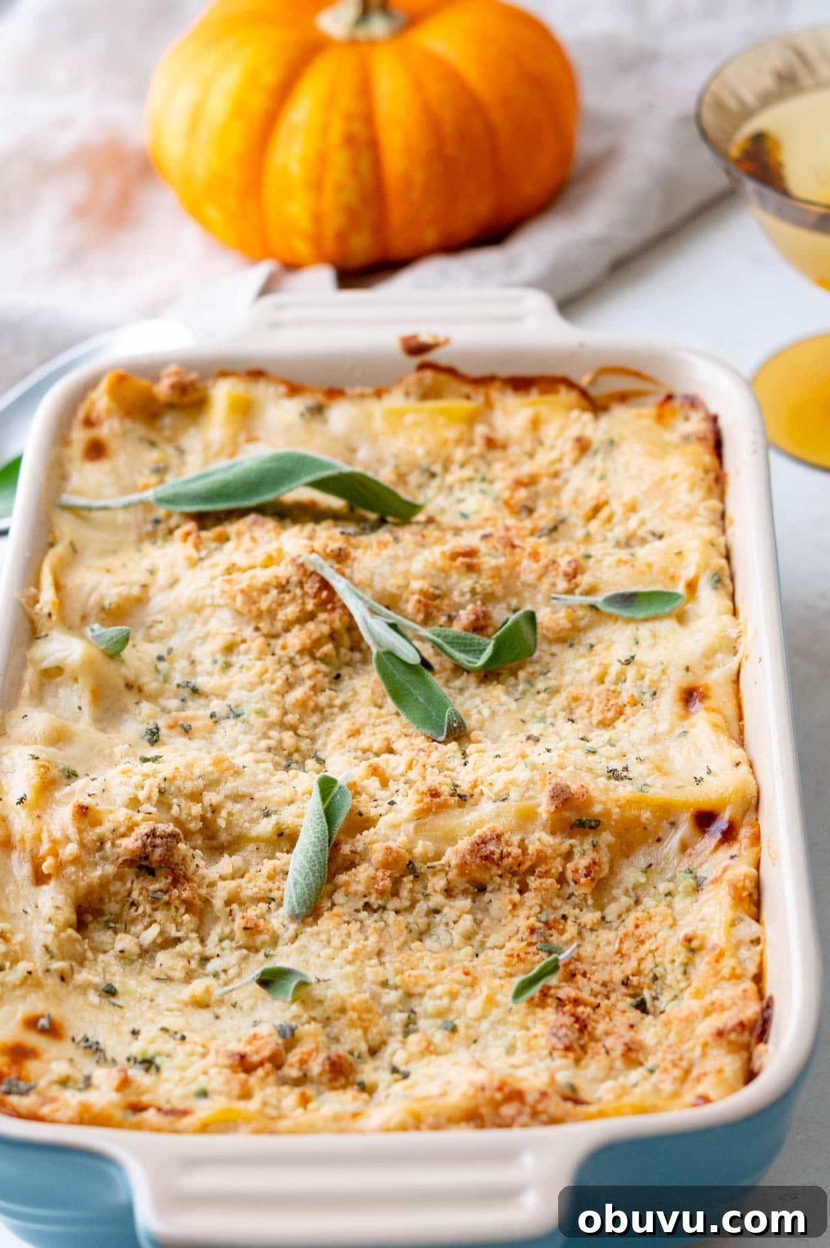Creamy Butternut Squash Lasagna with Sage and Ricotta 10 a sage embellished butternut squash lasagna, hot from the oven with a pumpkin in the background.