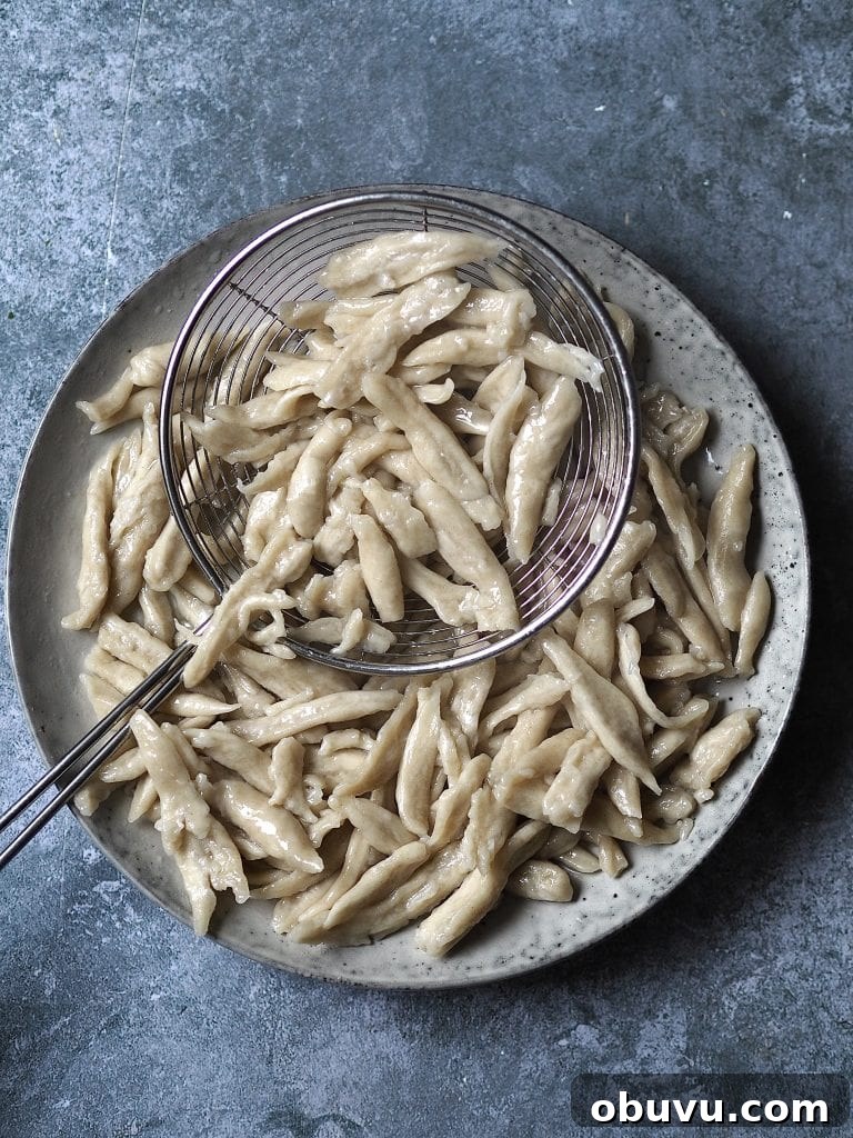 Boiled scissor-cut noodles on a grey plate.