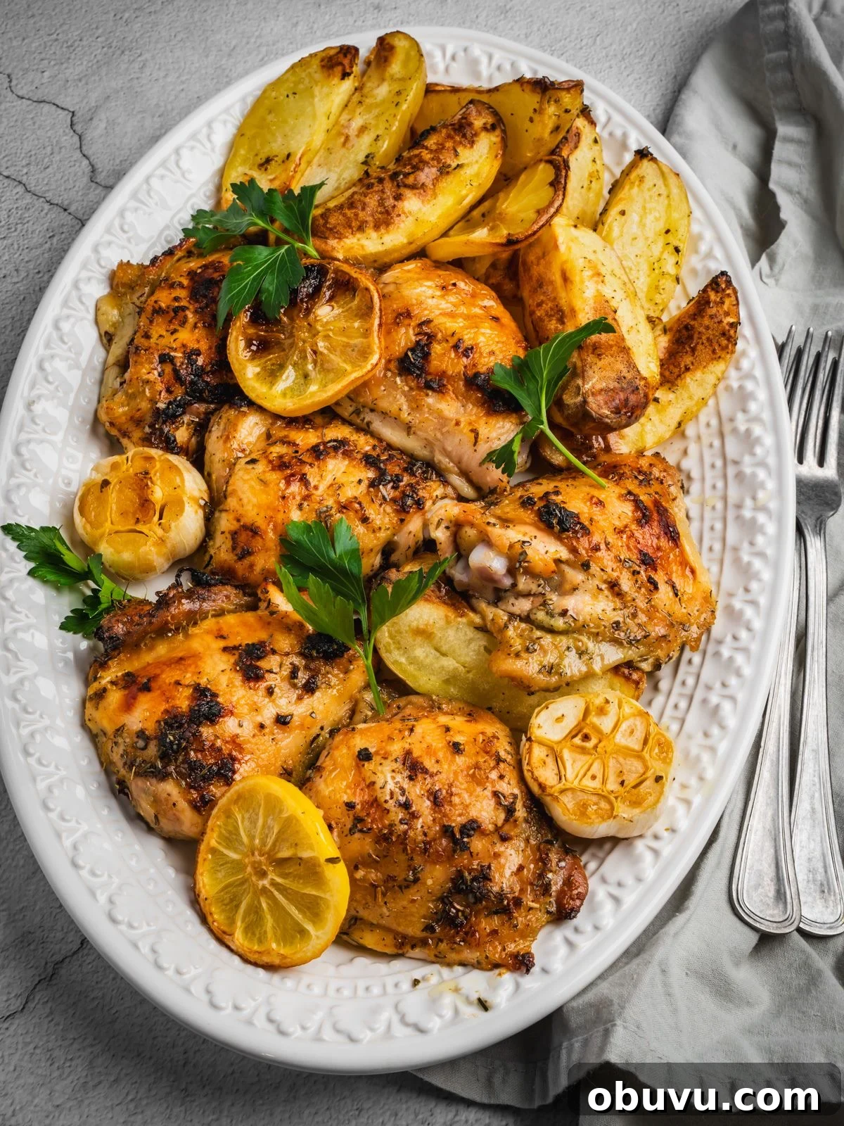 Greek chicken and potatoes in a serving dish.
