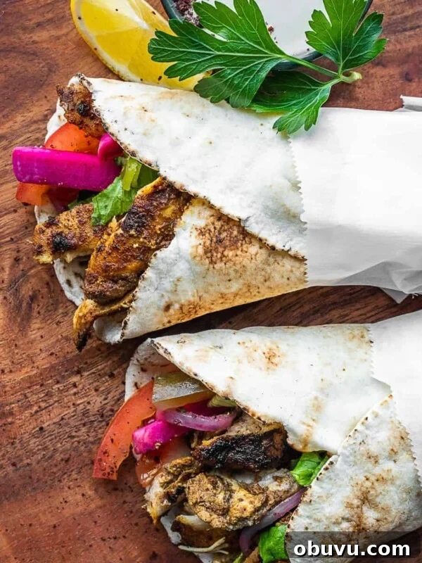 Chicken shawarma pita wraps on a board.