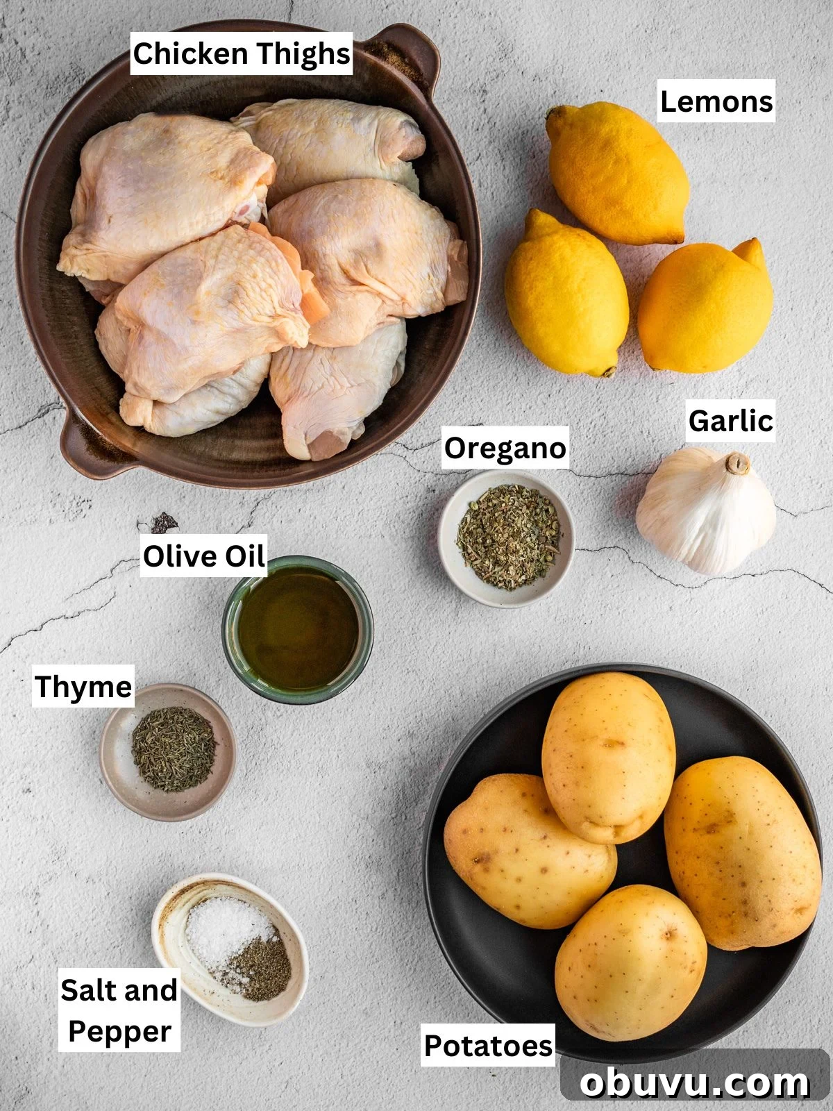 Greek lemon chicken and potatoes recipe ingredients with individual labels on a board.