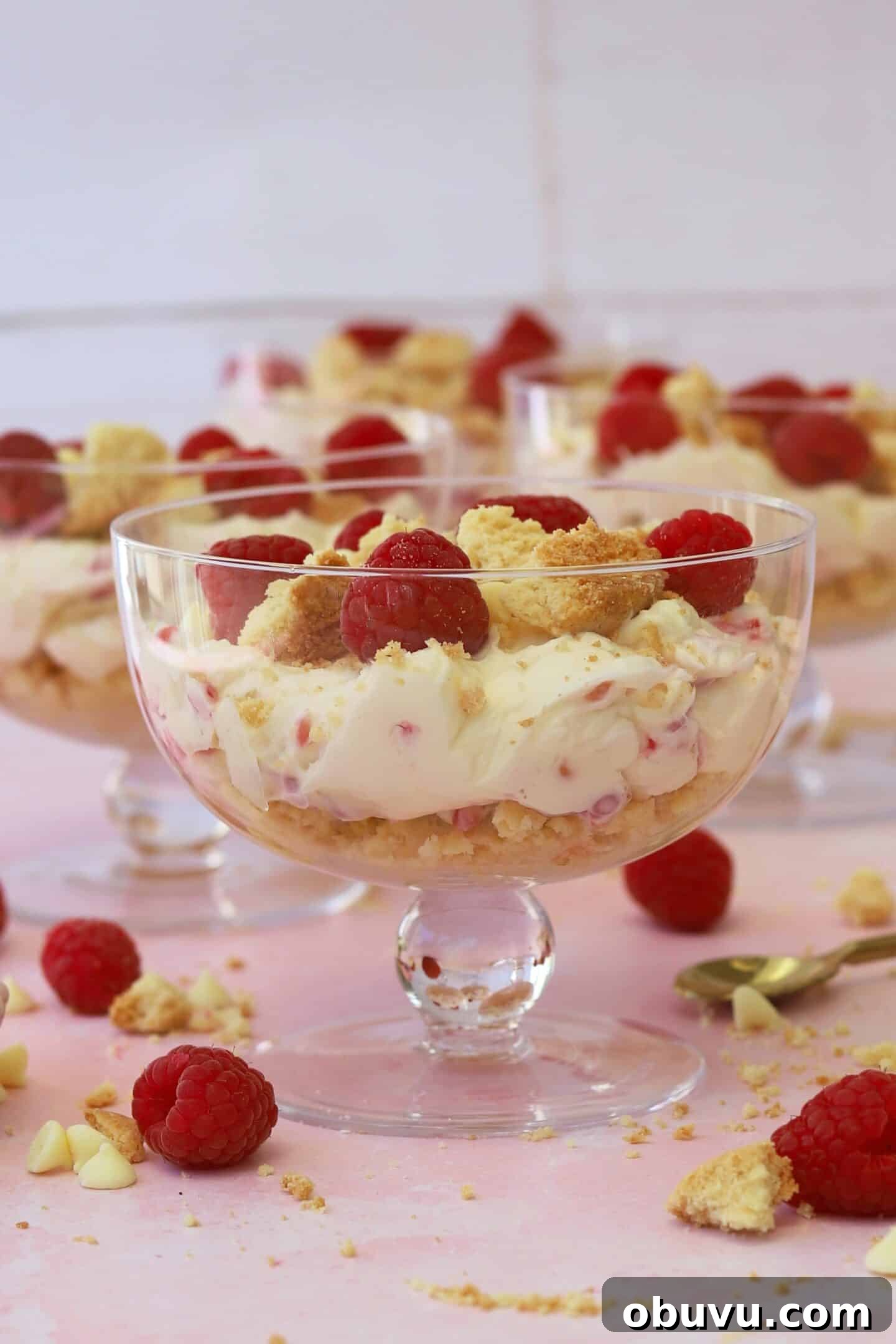 Raspberry and white chocolate cheesecakes in individual glass dishes.