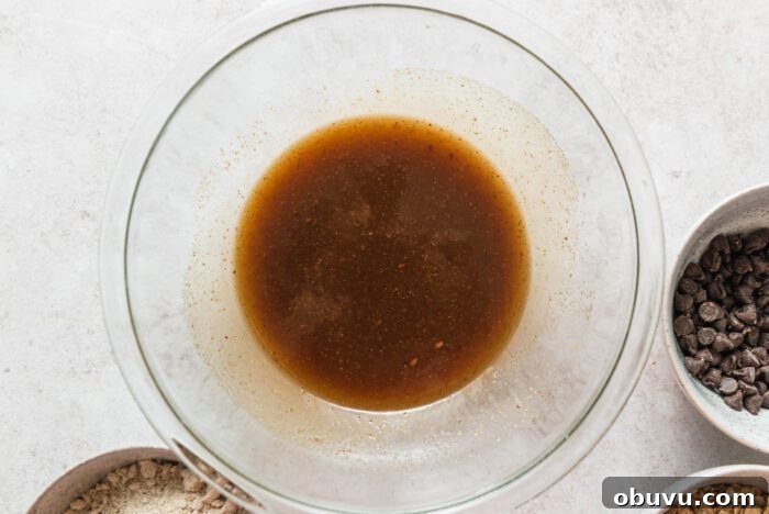 Brown sugar and melted butter mixed in a glass mixing bowl.