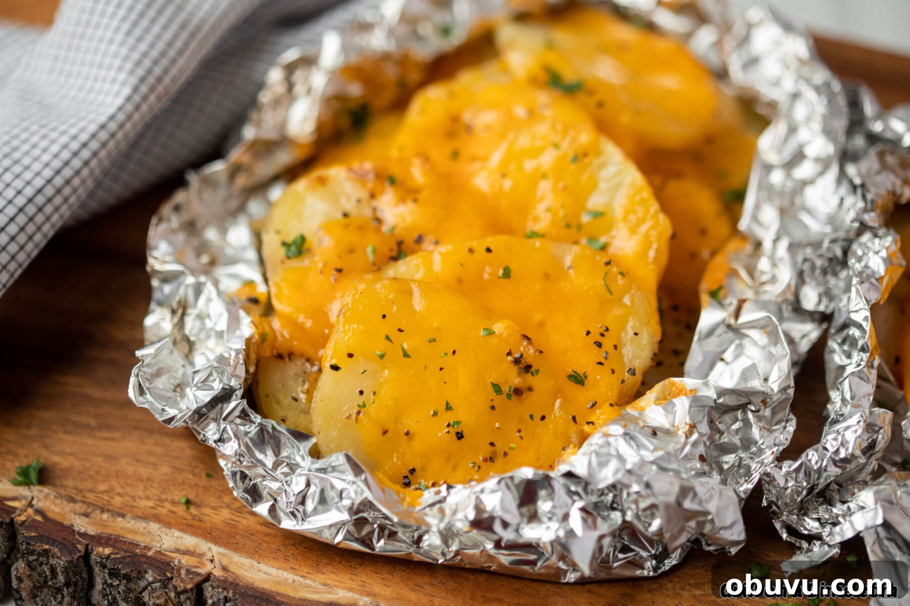 Slice potatoes in foil topped with melted cheese and pepper